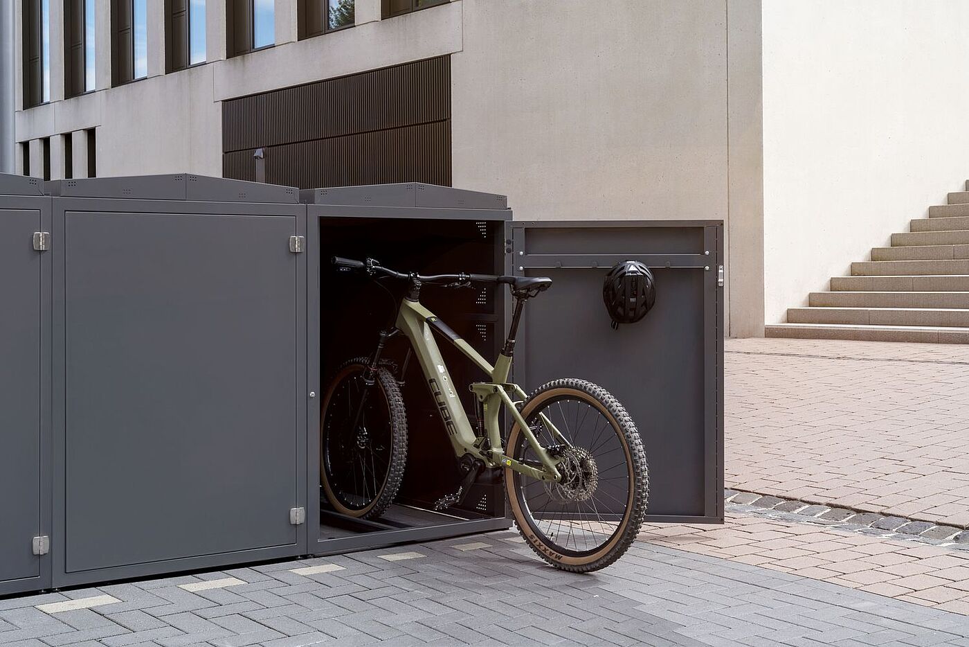 Ein Mountainbike vor der geöffneten Fahrradbox Piste-Kiste. 